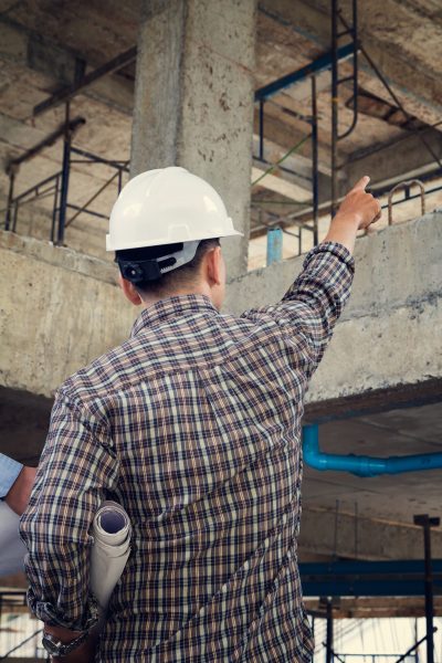 engineer with blueprint in building construction site